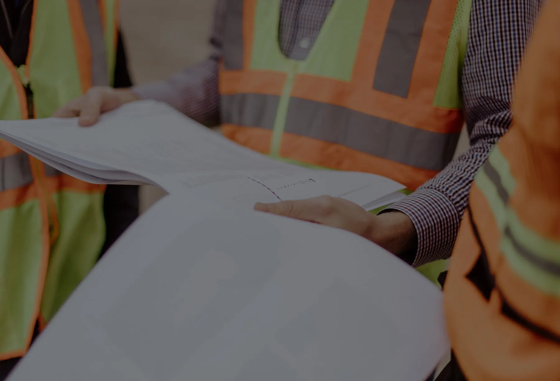 People in safety vests reviewing plans