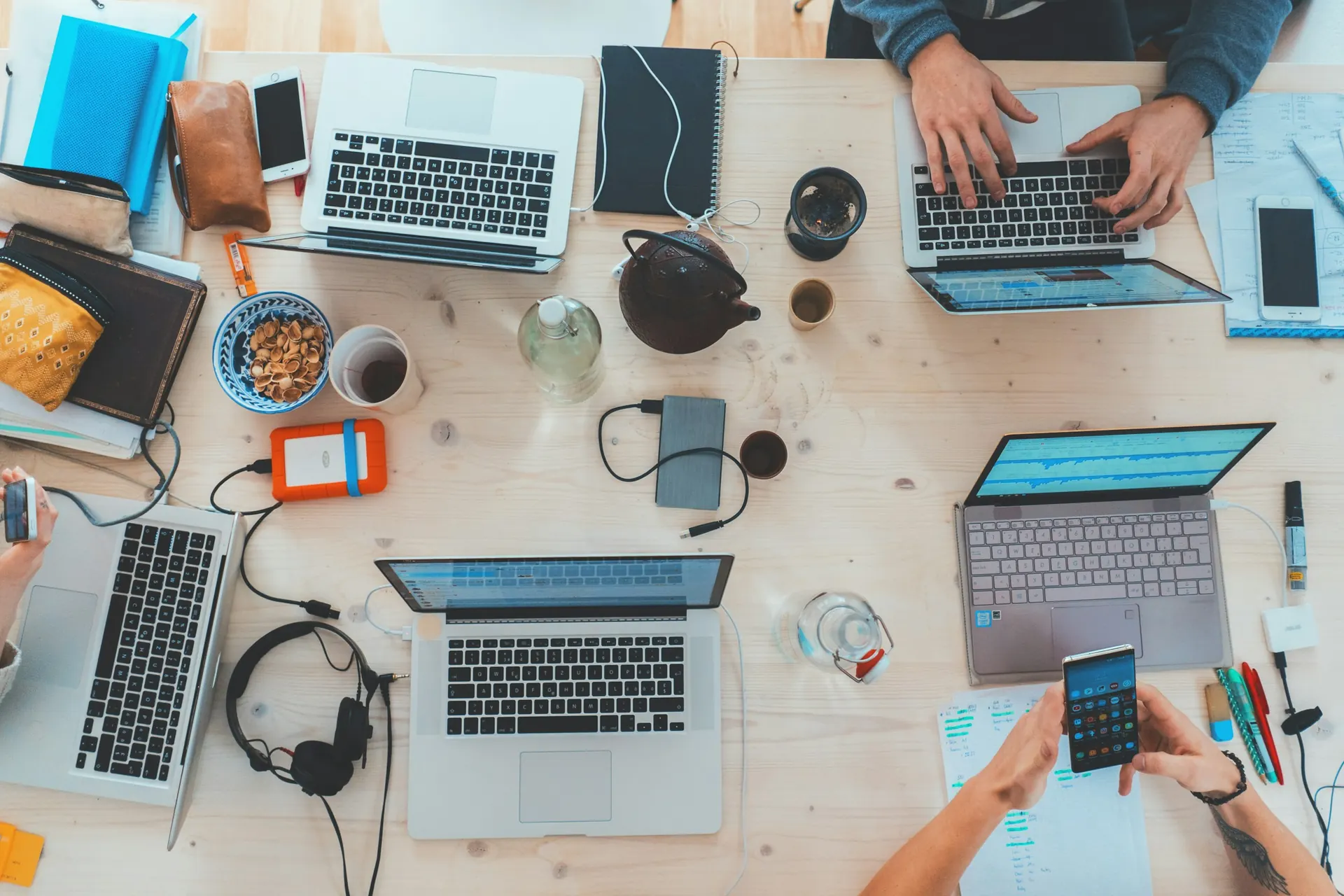 Overhead view of people working at laptops around a shared table